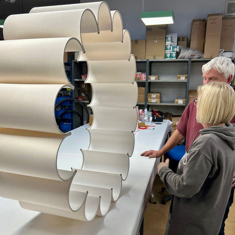 two people working on a large scalloped lampshade