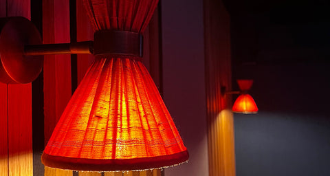 Bespkoe wall lamp with red silk gathered lamp shade in home cinema room