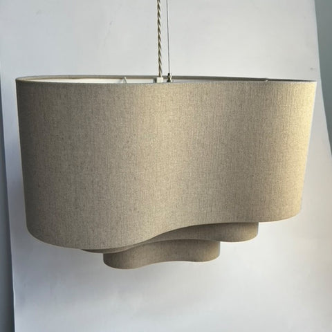 a natural linen 3 tiered lampshade in an unusual kidney shape