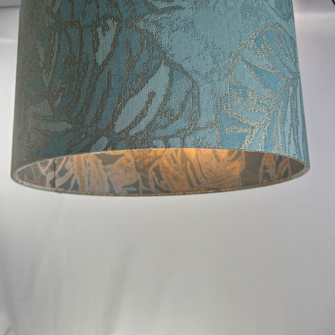 This striking peacock blue lampshade features intricate jacquard fabric with a velvet-like finish. Its frosted inner lining enhances its refined design.