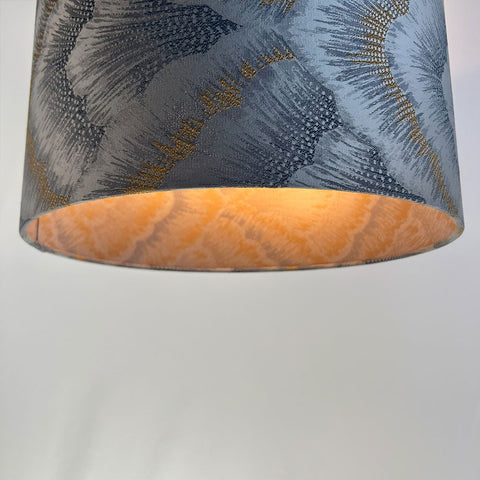 This elegant silver lampshade boasts a beautiful jacquard fabric with a delicate pattern. The beach gold frame and frosted inner lining offer a chic, timeless look for modern interiors.”