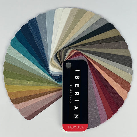 A set of fabric sample swatches in various colors spread out with the brand name 'IBERIAN' visible on one of the swatches labeled 'COTTON'.