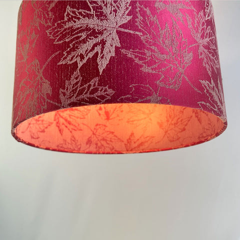 A vibrant fuchsia red drum lampshade with a delicate maple leaf pattern in a rich jacquard fabric. The shade features a frosted clear inner lining, creating modern elegant look to fit any room. Available in various sizes for table lamps, floor lamps and as a pendant, it is perfect for contemporary and traditional interiors