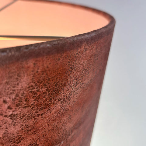 a close-up detail view of a velvet drum lampshade in rich copper brown with gold highlights, showing a frosted clear inner lining and beach gold frame; complements Pantone’s 2025 Colour of the Year, Mocha Mousse.