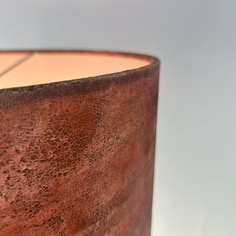 a close-up detail view of a velvet drum lampshade in rich copper brown with gold highlights, showing a frosted clear inner lining; complements Pantone’s 2025 Colour of the Year, Mocha Mousse.
