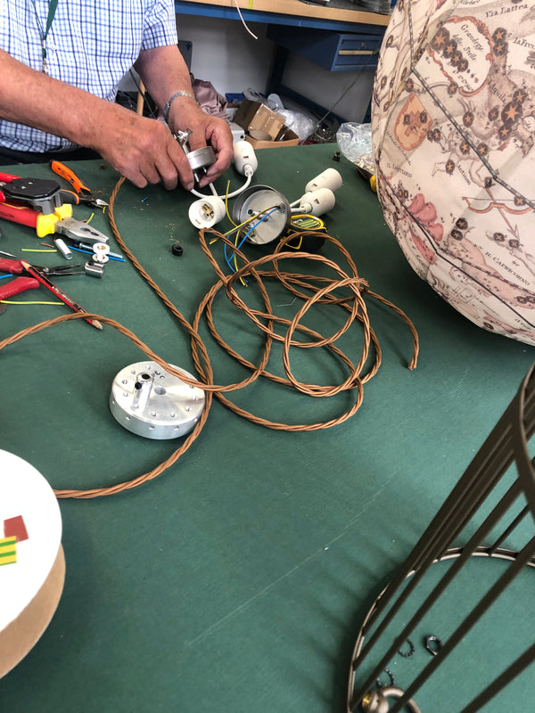 Person working on electrical wiring with tools on a green surface