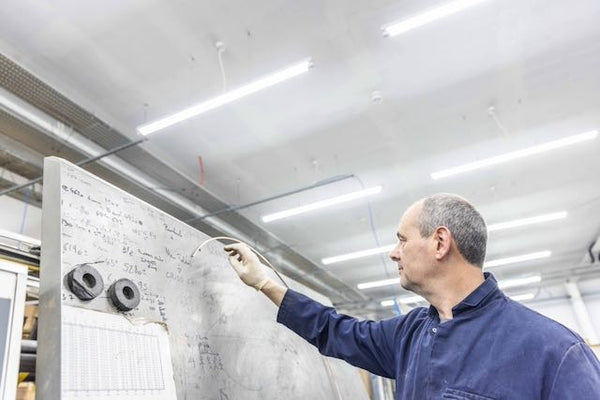Person working on a large panel with text in an indoor setting